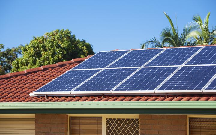 A photo of a house roof with solar panels on top